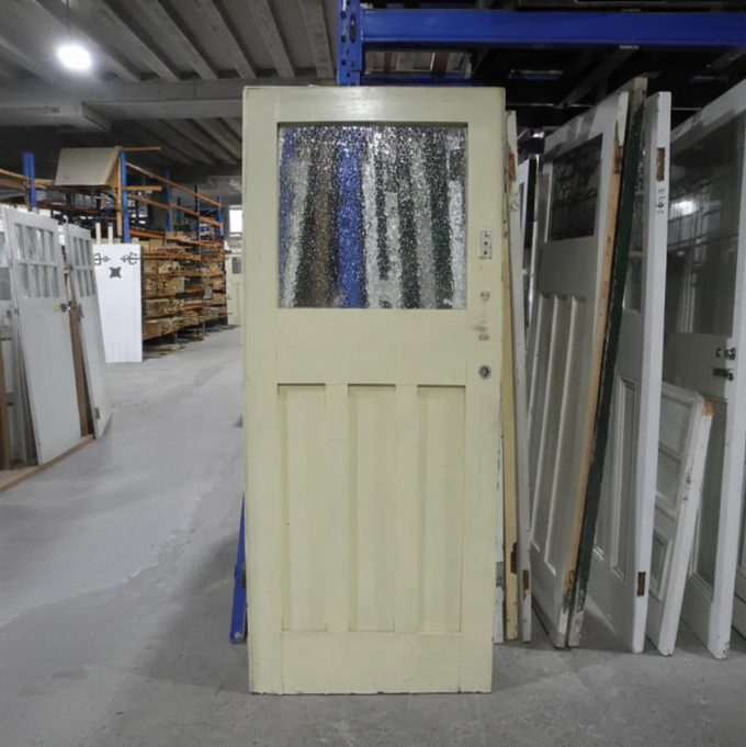 Salvaged Edwardian solid timber front door in a light cream finish, featuring a large upper textured privacy glass window and traditional three-panel lower design, available to buy at Chippendale Restorations second hand doors yard.