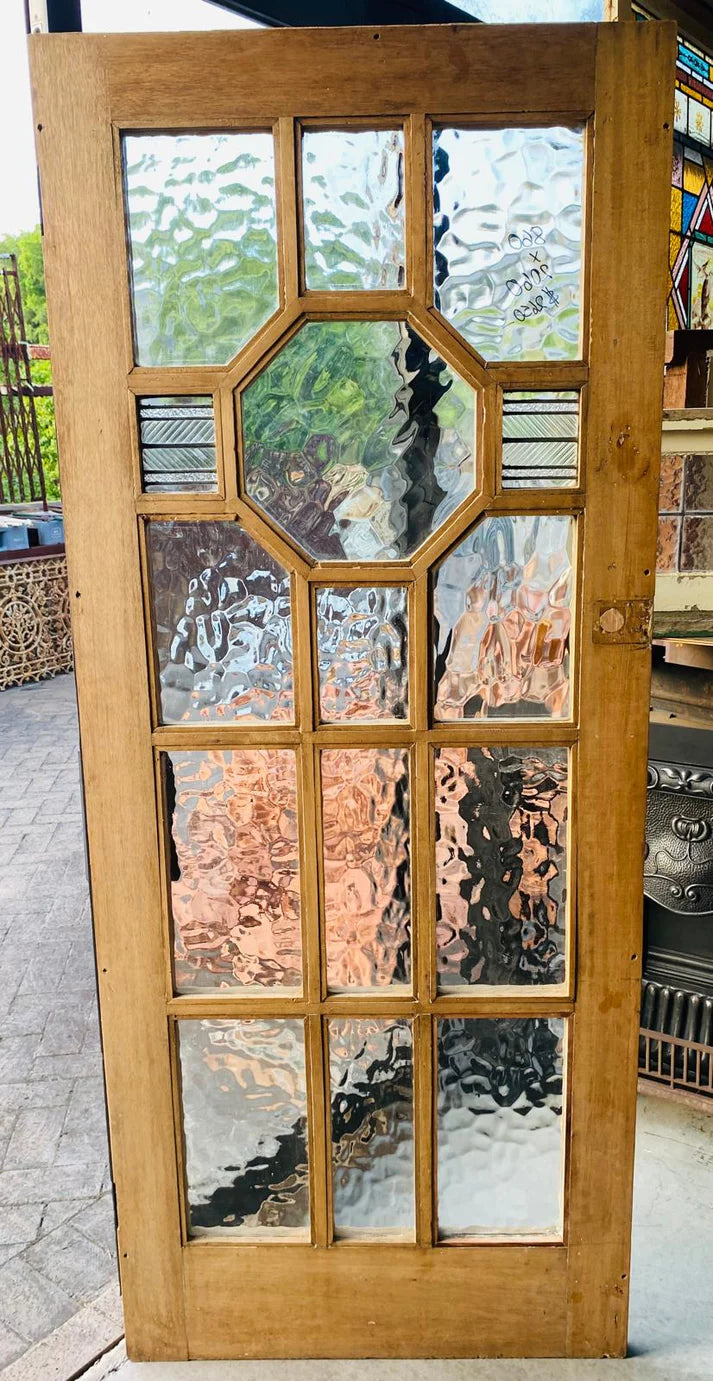 Elegant 1920s Queensland Maple timber front door featuring a prominent arched leadlight window panel with red and amber stained glass accents from Chippendale Restorations second hand doors selection.