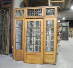 Original Arts and Crafts solid timber front entry door featuring high-set stylized floral leadlight glass panels from Chippendale Restorations second hand doors yard.