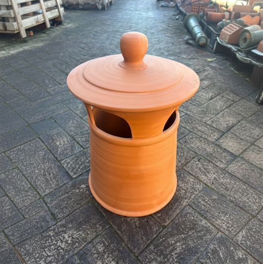 An original large terracotta clay chimney pot with a weathered finish and horizontal ribbing, displayed outside at the Chippendale Restorations heritage architectural yard.