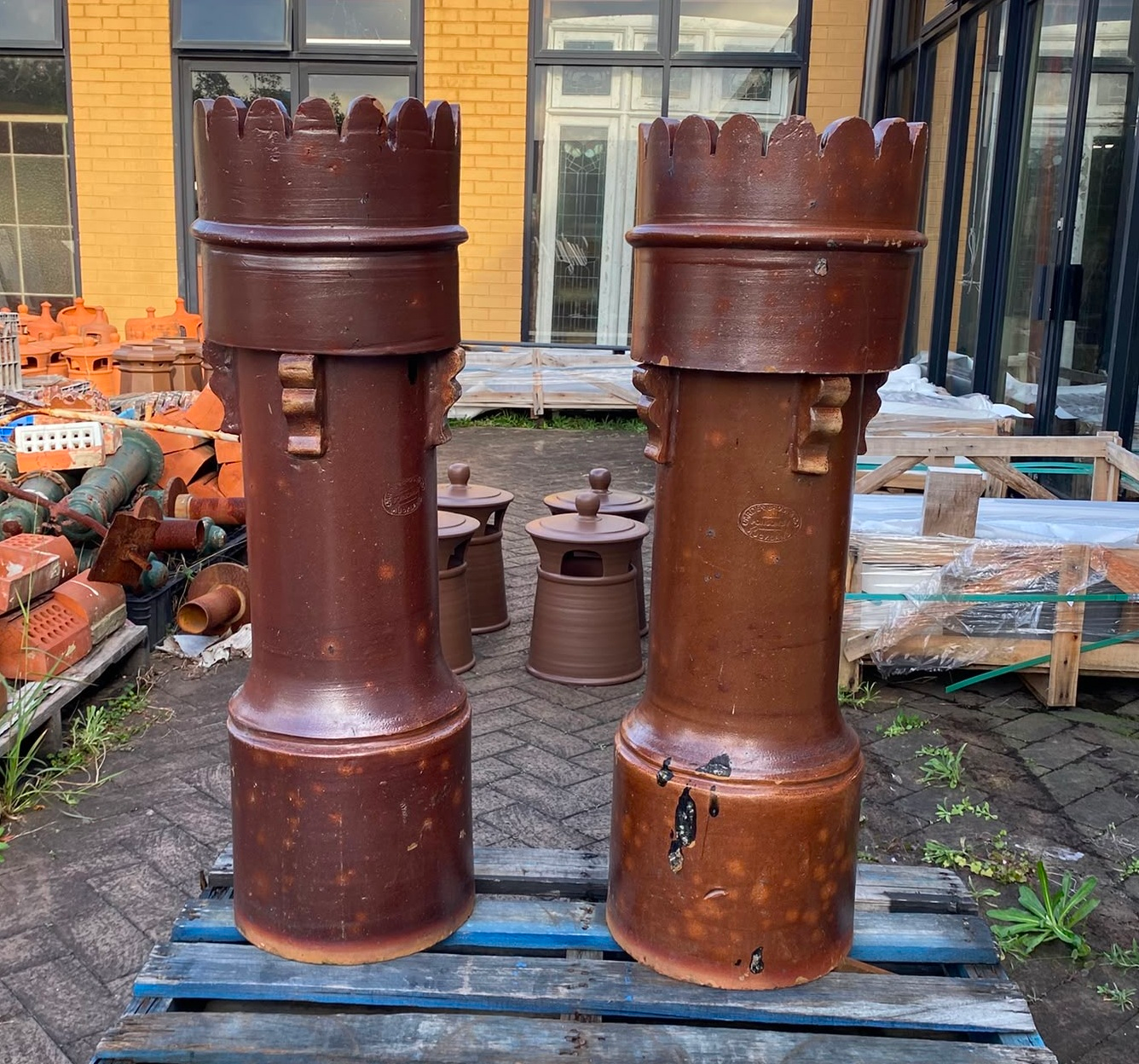 Pair of original extra-large salvaged clay chimney pots with a naturally weathered patina and horizontal ribbing, displayed at Chippendale Restorations heritage building yard.