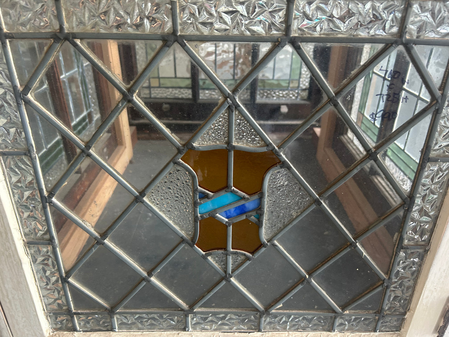 An original salvaged antique leadlight window set in a dark timber frame, featuring textured clear privacy glass with vibrant green and amber geometric borders at Chippendale Restorations.