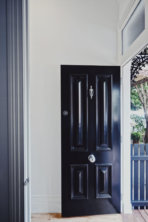 Ornate classic Victorian style door knockers shown in various metallic finishes and mounted on traditional dark timber front doors.