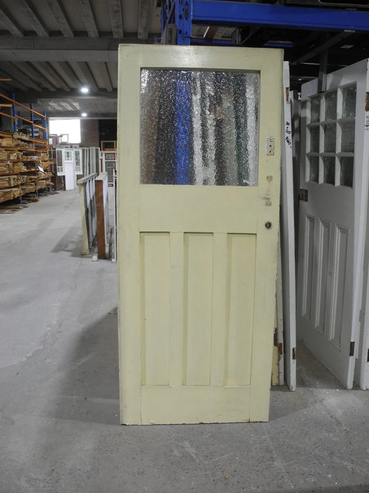 Original Edwardian solid timber front door featuring an elegant geometric leadlight glass window panel, available to buy at Chippendale Restorations second hand doors yard.