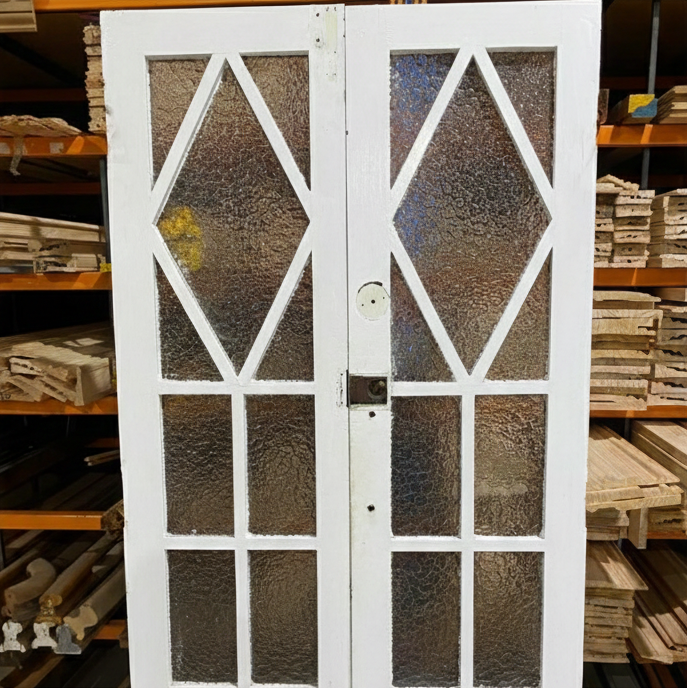 A pair of original salvaged 1920s timber French doors with multi-pane glazing and prominent central amber diamond leadlight windows, on display at Chippendale Restorations.