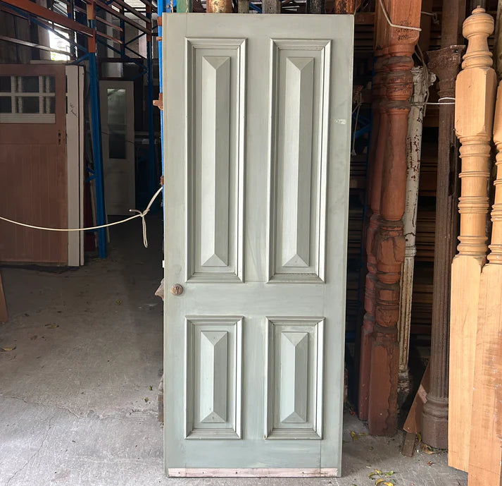Classic four-panel solid timber internal door displaying natural wood grains, available to buy at Chippendale Restorations second hand doors yard.