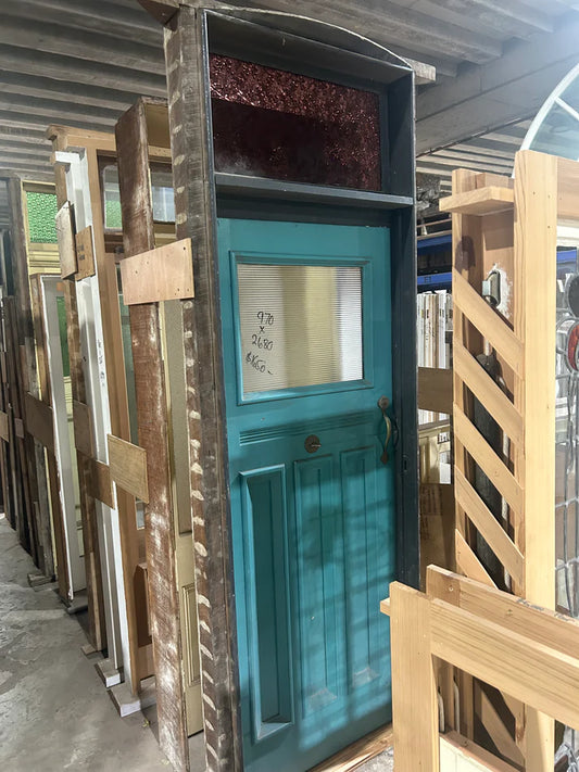 An original salvaged Federation style external entryway timber door painted white, showcasing a large upper window panel with beautiful red, amber, and blue geometric leadlight privacy glass at Chippendale Restorations.