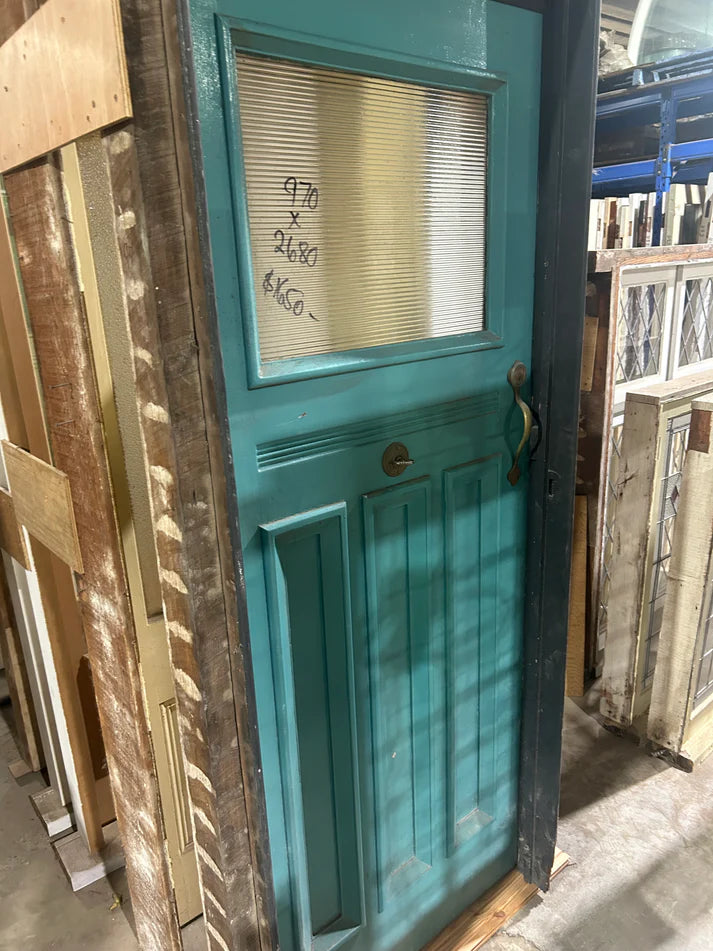 An original salvaged Federation style external entryway timber door painted white, showcasing a large upper window panel with beautiful red, amber, and blue geometric leadlight privacy glass at Chippendale Restorations.