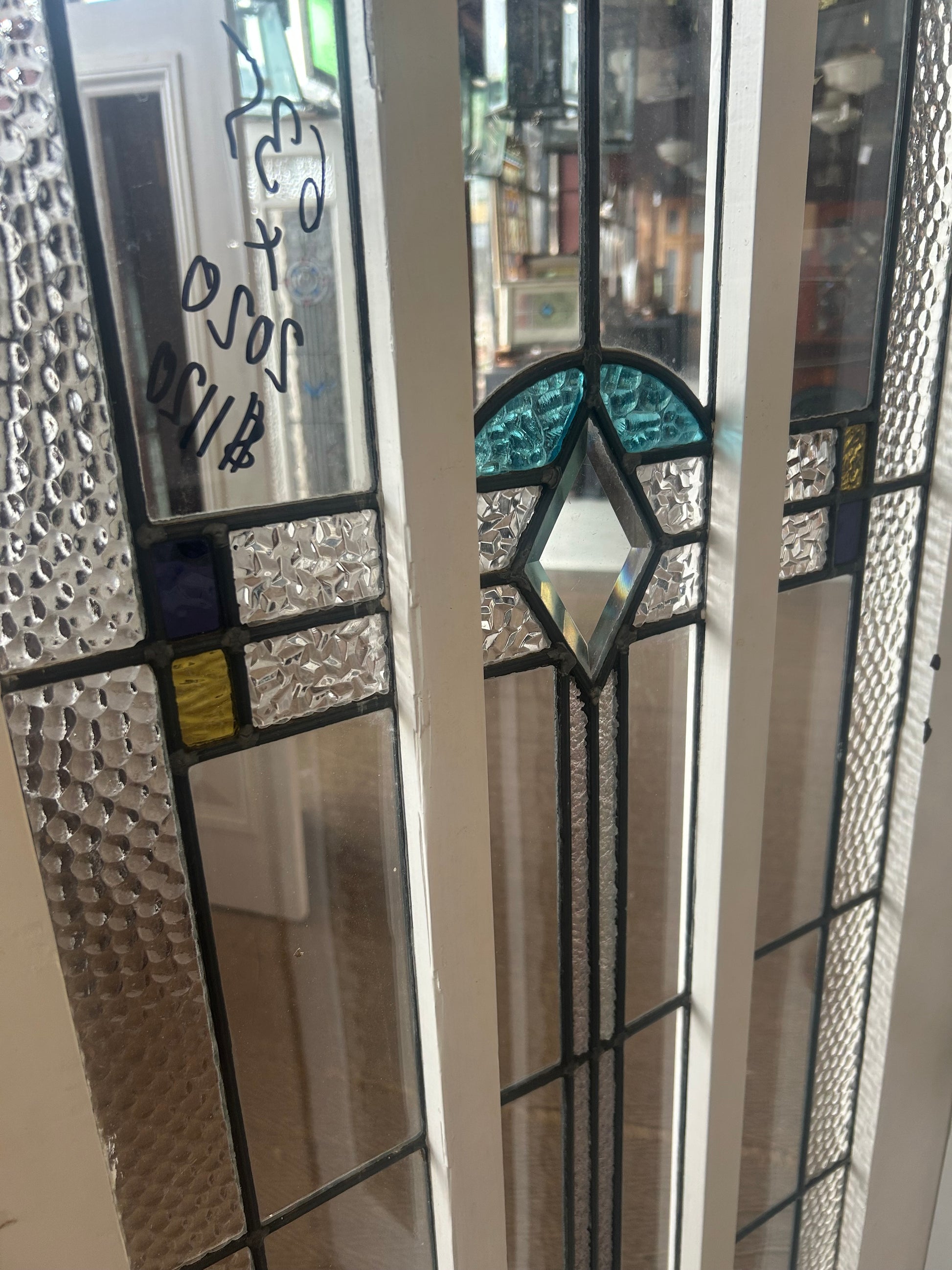 An original salvaged timber Federation entry door painted white, showcasing an elongated vertical window with multi-lite privacy leadlight glass and a central turquoise accents layout inside the Chippendale Restorations architectural salvage showroom.