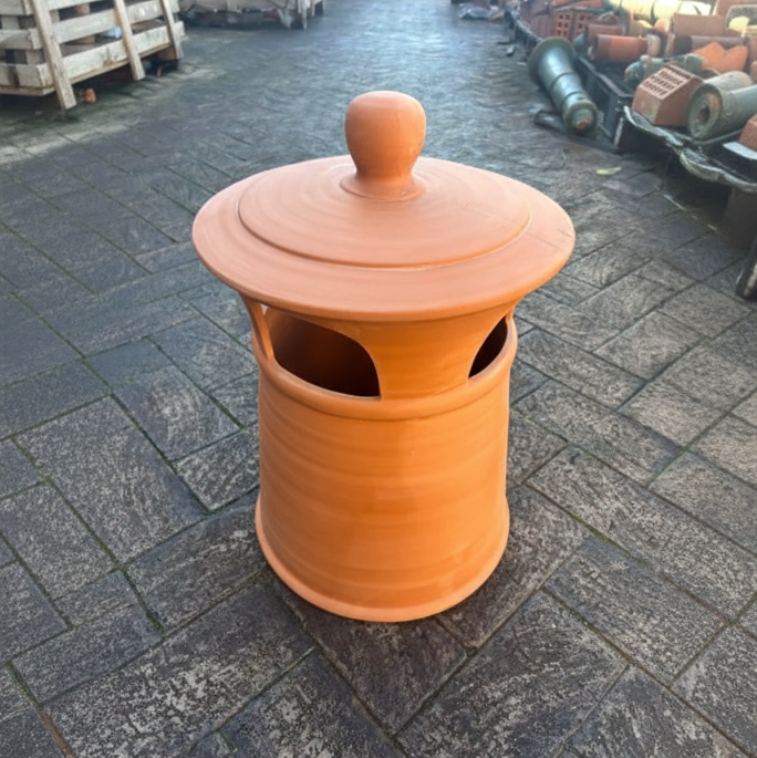 An original large terracotta clay chimney pot with a weathered finish and horizontal ribbing, displayed outside at the Chippendale Restorations heritage architectural yard.