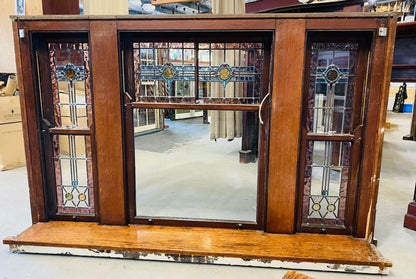 A set of original salvaged triple double-hung timber windows painted green on the exterior frame, showcasing classic multi-pane glass panels on display at Chippendale Restorations.