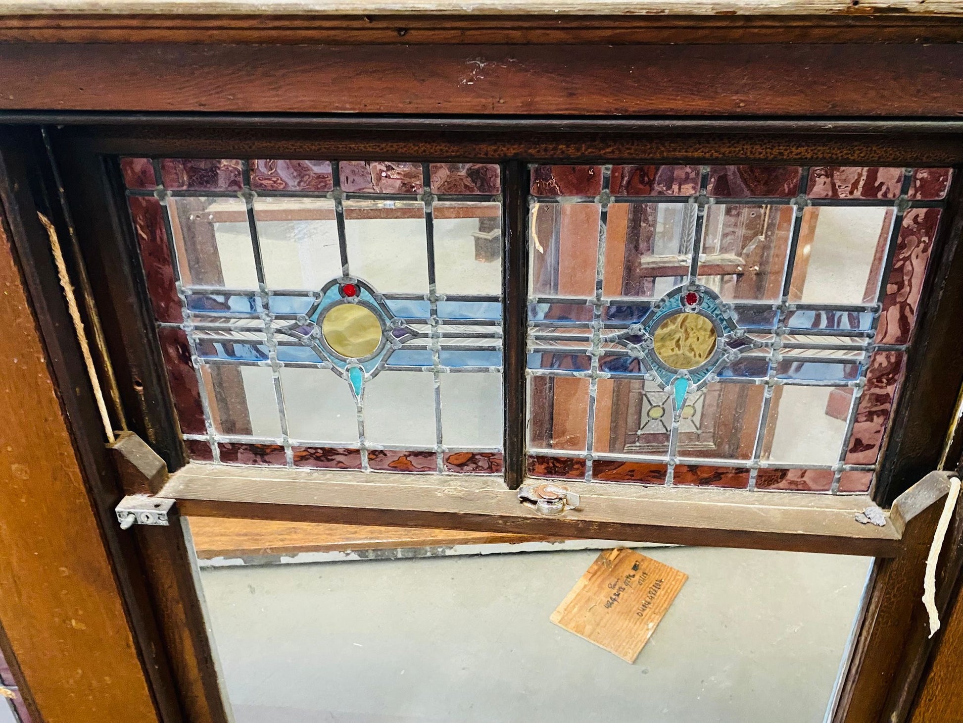 A set of original salvaged triple double-hung timber windows painted green on the exterior frame, showcasing classic multi-pane glass panels on display at Chippendale Restorations.