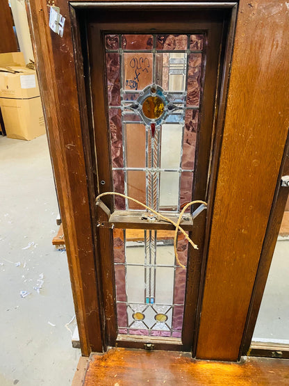 A set of original salvaged triple double-hung timber windows painted green on the exterior frame, showcasing classic multi-pane glass panels on display at Chippendale Restorations.