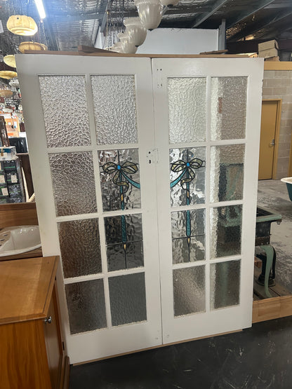 An original salvaged Federation style timber door painted white, showcasing an upper vertical three-panel window layout with elegant purple and green leadlight privacy glass on display at Chippendale Restorations.