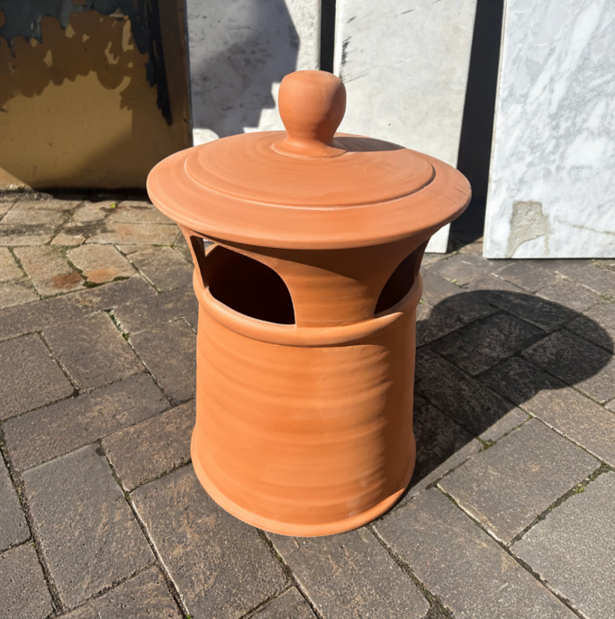 An original small terracotta clay chimney pot with a weathered finish and horizontal ribbing, displayed outside at the Chippendale Restorations heritage architectural yard.