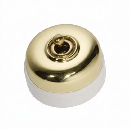 Porcelain-based electrical switch with a visible metal dolly. Available in a polished brass or antique brass finish on either a white porcelain base or a black porcelain base.