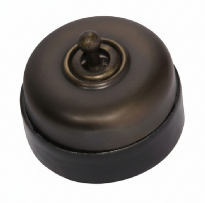 Porcelain-based electrical switch with a visible metal dolly. Available in a polished brass or antique brass finish on either a white porcelain base or a black porcelain base.