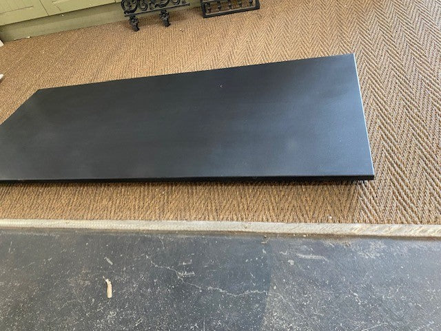 Honed black granite hearth slab featuring a smooth matte non-reflective finish fitted under a vintage cast iron fireplace