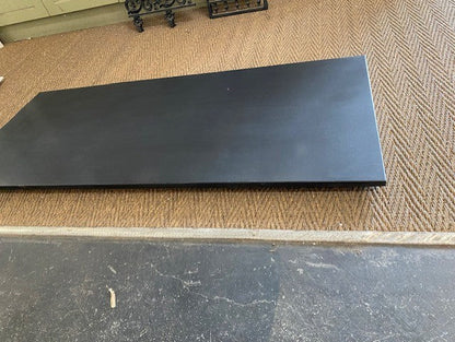 Honed black granite hearth slab featuring a smooth matte non-reflective finish fitted under a vintage cast iron fireplace