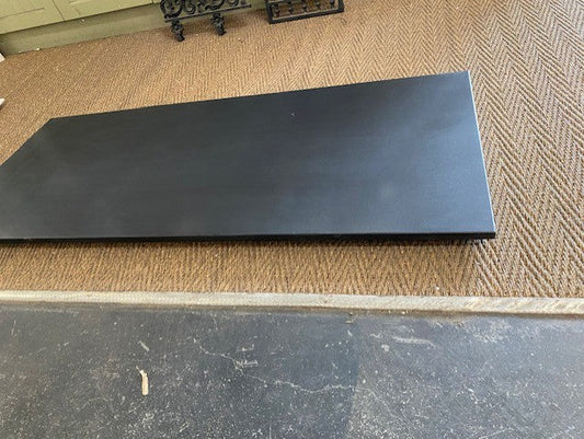 Honed black granite hearth slab featuring a smooth matte non-reflective finish fitted under a vintage cast iron fireplace