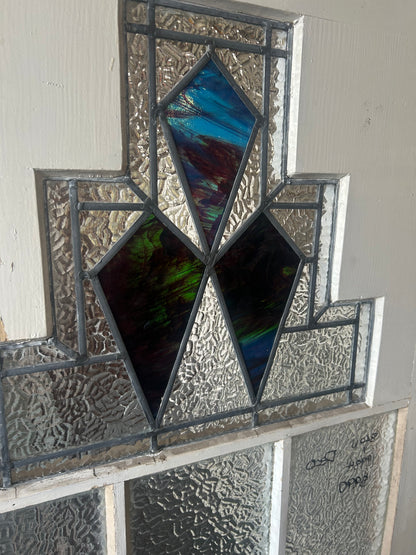 An original salvaged 1930s Art Deco style timber door painted white, featuring an upper window panel with geometric leadlight privacy glass and stained glass accents, on display at Chippendale Restorations.