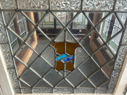 An original salvaged antique leadlight window set in a dark timber frame, featuring textured clear privacy glass with vibrant green and amber geometric borders at Chippendale Restorations.