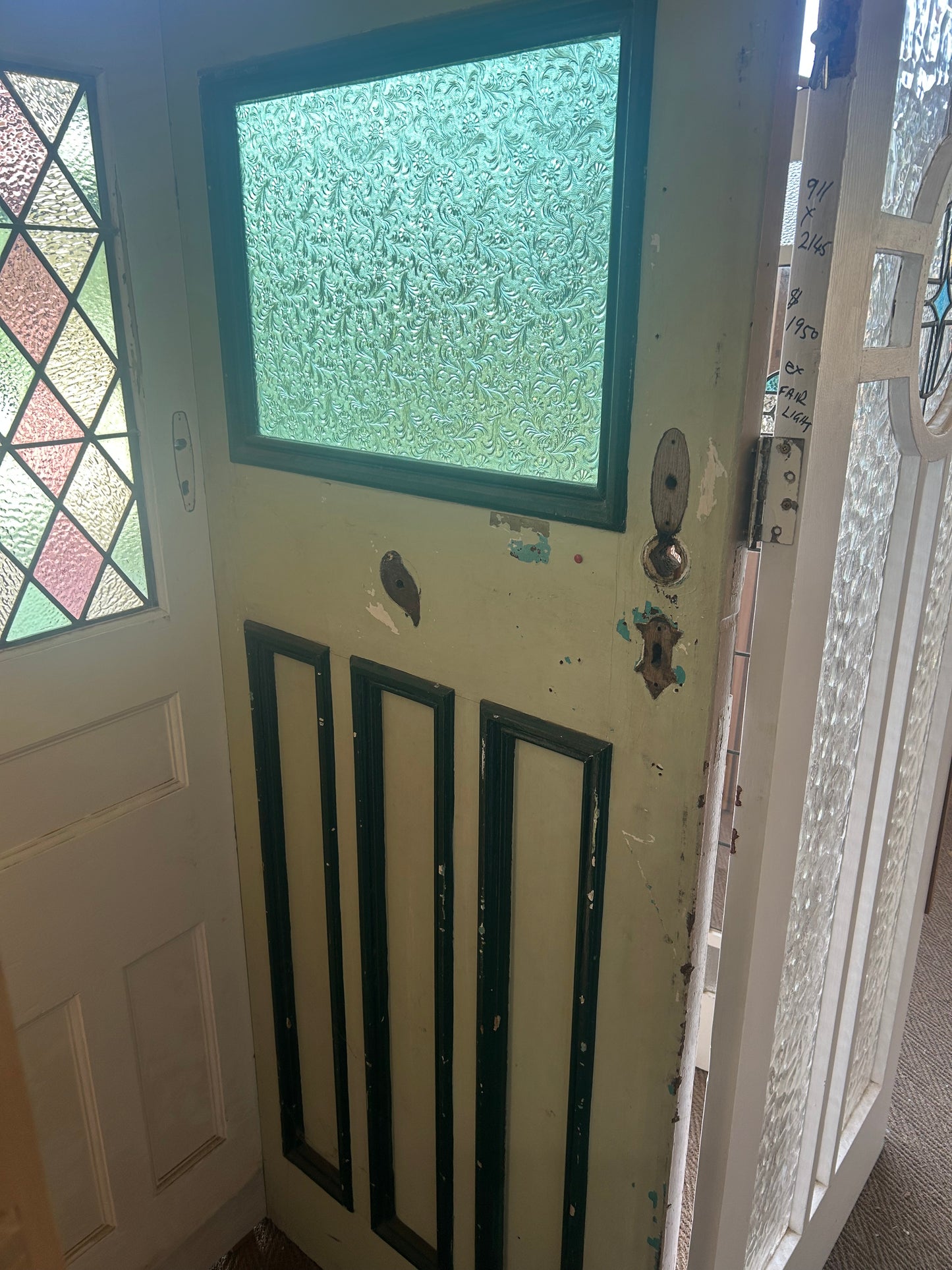 An original salvaged four-panel Edwardian timber internal door painted white, showcasing traditional deep-moulded panels on display at Chippendale Restorations.