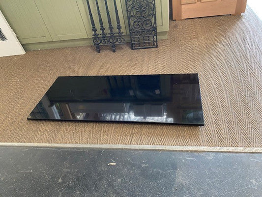 Polished black granite hearth slab with a high-gloss reflective finish installed beneath a fireplace