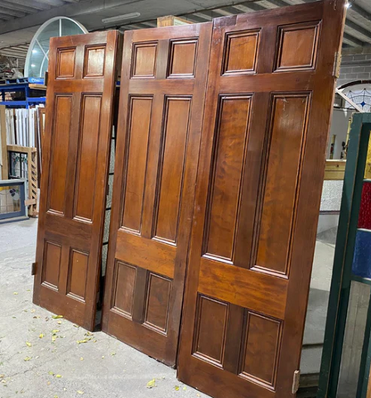 Set of three vintage 6-panel redwood room dividing doors with a rich timber finish, showcased at Chippendale Restorations second-hand door warehouse.