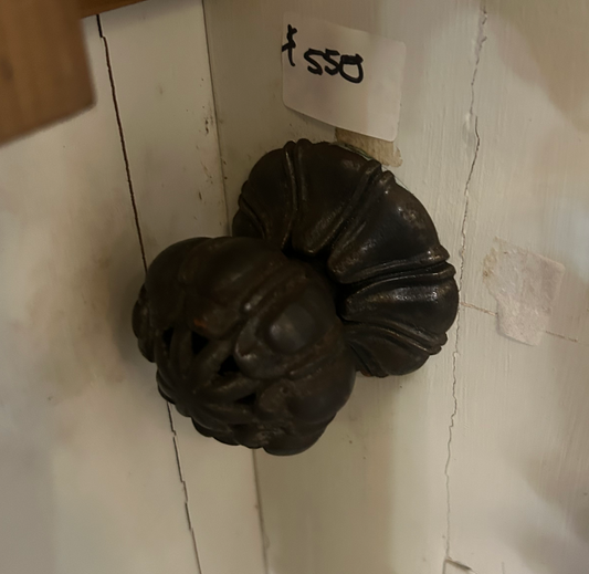 A close-up of an authentic, salvaged antique centre door knob made of solid brass with a deep, natural aged patina. The knob features a classic circular design with a stepped rose plate and visible wear that highlights its historical character and superior second-hand quality.