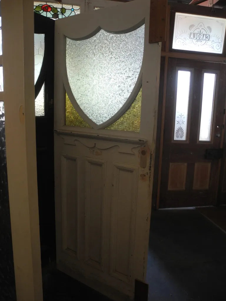 Detailed view of an Edwardian front door leadlight panel with multi-textured glass, red borders, and a central shield geometric motif from Chippendale Restorations.