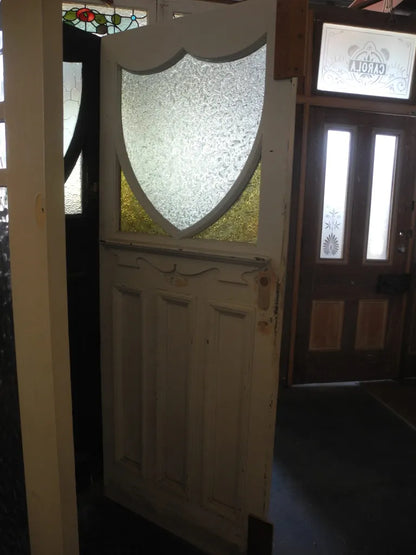 Detailed view of an Edwardian front door leadlight panel with multi-textured glass, red borders, and a central shield geometric motif from Chippendale Restorations.