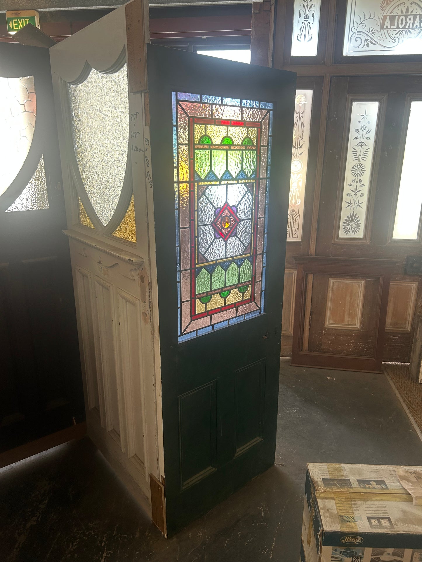 Detailed view of a Victorian front door leadlight panel showing multi-textured glass, green borders, and a central amber jewel, available to buy at Chippendale Restorations.