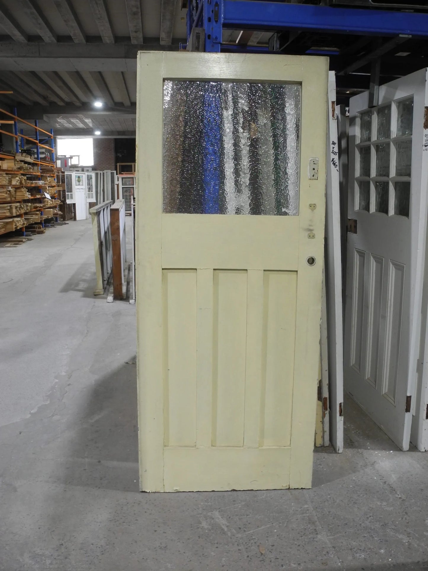 Original Edwardian solid timber front door featuring an elegant geometric leadlight glass window panel, available to buy at Chippendale Restorations second hand doors yard.
