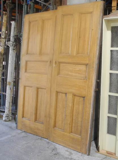 A matching pair of original salvaged Federation timber sliding doors painted white, featuring a multi-lite clear glass window design on the upper half, inside the Chippendale Restorations showroom.