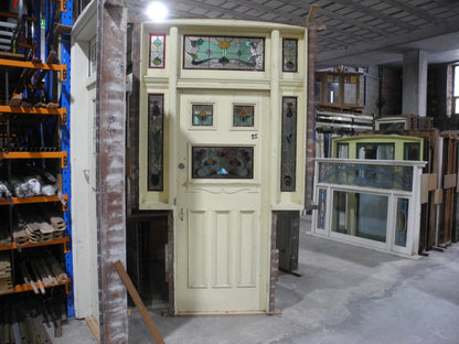 A spectacular original salvaged timber Federation entranceway door painted white, showcasing a large upper window with intricate textured privacy leadlight glass and vibrant red and amber stained glass accents on display at Chippendale Restorations.