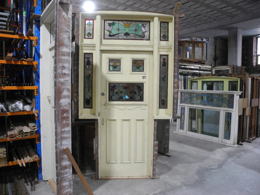 A spectacular original salvaged timber Federation entranceway door painted white, showcasing a large upper window with intricate textured privacy leadlight glass and vibrant red and amber stained glass accents on display at Chippendale Restorations.